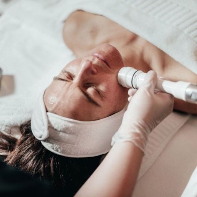 Mulher a receber tratamento facial com aparelho num spa