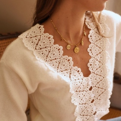 Blusa branca com gola rendada e acessórios dourados