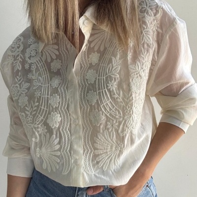 Camisa branca bordada de mulher com jeans azul claro