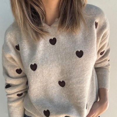 Camisola de malha bege com corações castanhos bordados e calças jeans