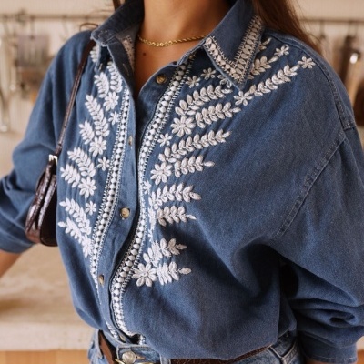 Camisa azul de ganga bordada com padrão floral branco