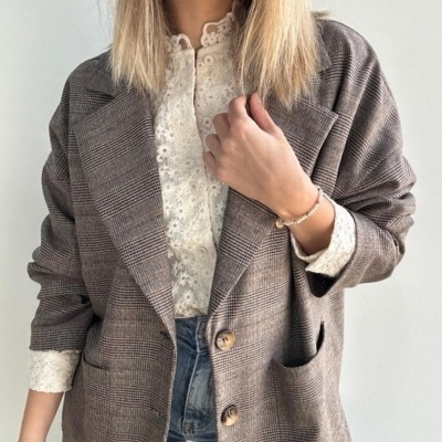 Blazer castanho às riscas com camisa branca de renda e jeans azuis