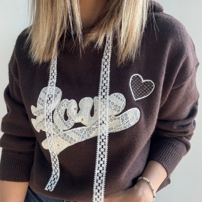 Camisola castanha com decoração rendada branca e a palavra 'love'