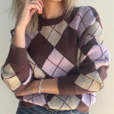 Camisola de malha castanha com padrão em losangos bege e lilás, usada com jeans azul.