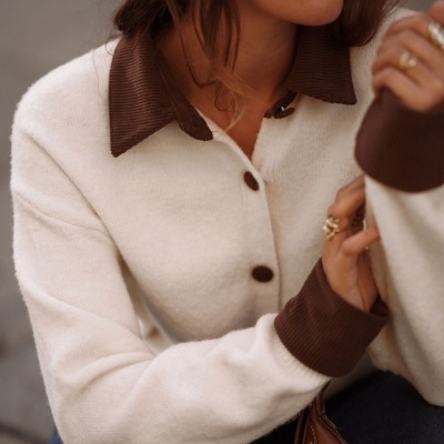 Camisa de malha branca com botões castanhos e detalhes castanhos no colarinho e punhos