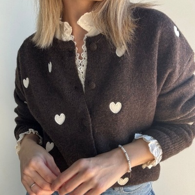 Cardigã castanho escuro com corações brancos e blusa branca com renda