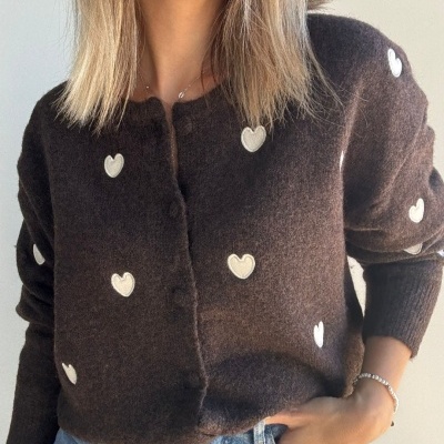 Casaco castanho escuro com corações brancos e calças de ganga azuis