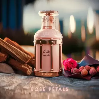 Frasco de perfume dourado REHAM com pétalas de rosa e elementos naturais em fundo desfocado