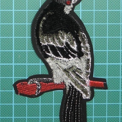 Emblema Passaro 11,5cm x 7cm com Bordado sobre Camurça com base de cola, e um brilhante como Olho.