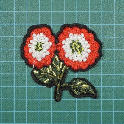 Aplicação bordada de duas flores vermelhas e brancas com contas