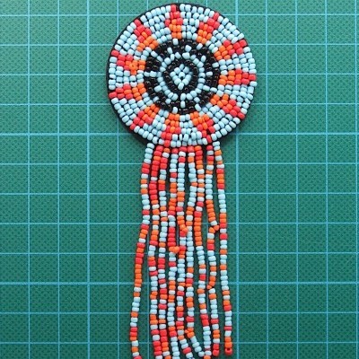 Artesanal de contas coloridas em fundo verde quadriculado