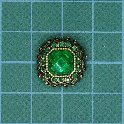 Anel decorativo com pedra central verde e detalhes dourados