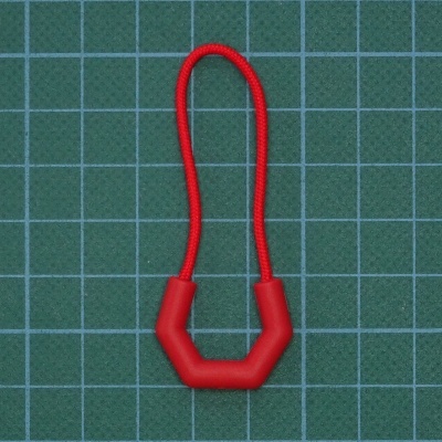 Elástico vermelho com encaixe hexagonal vermelho sobre fundo verde quadriculado