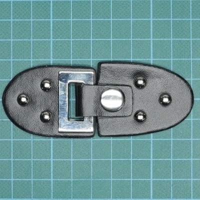 Fecho de couro preto com metal prateado sobre fundo verde com grelha branca