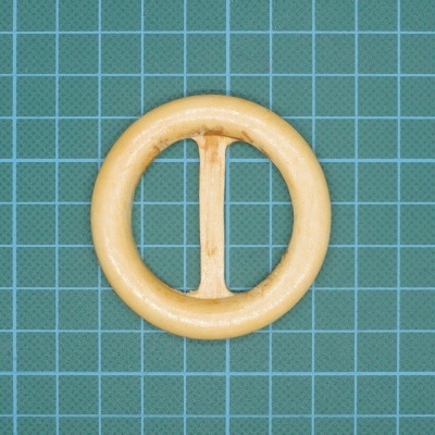 Anel de cortina redondo de madeira clara com barra vertical sobre fundo quadriculado verde azulado