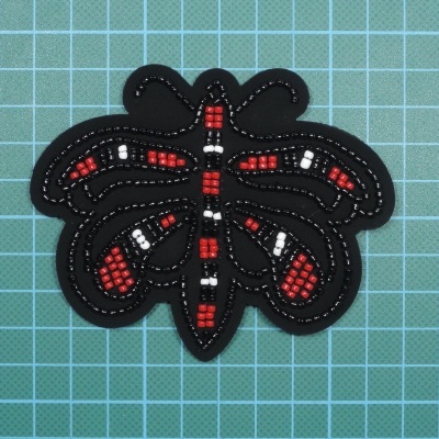 Patch de tecido preto com contas vermelhas, brancas e pretas em formato de inseto