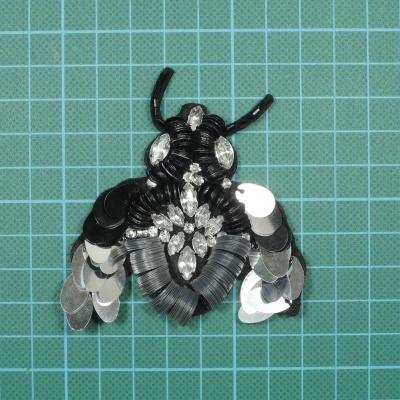 Inseto 8cm x 7cm com Lantejoulas cosidas sobre base de feltro com cola.