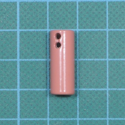 Bateria cilíndrica rosa com dois orifícios em superfície quadriculada azul