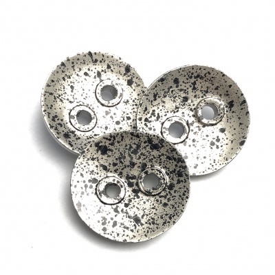 Três botões brancos com manchas pretas e dois furos