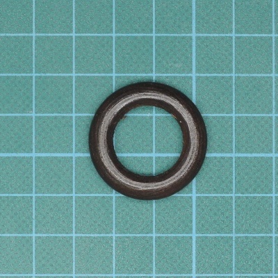 Anel de vedação preto sobre superfície azul com grelha quadrada