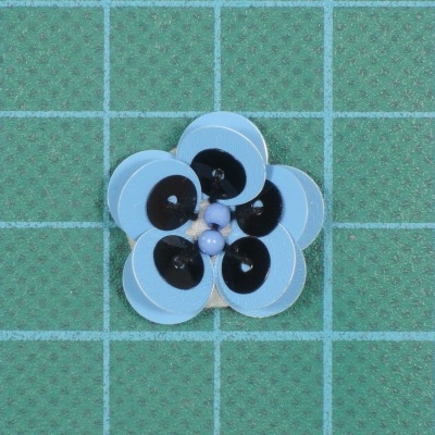 Flor 2cm Lantejoulas, e Missangas cosidas sobre base de feltro com cola.