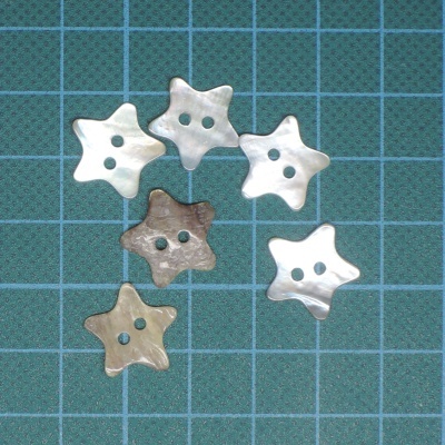 Botões estrela perolados sobre grade azul