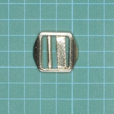 Fecho metálico prateado quadrado sobre superfície quadriculada verde