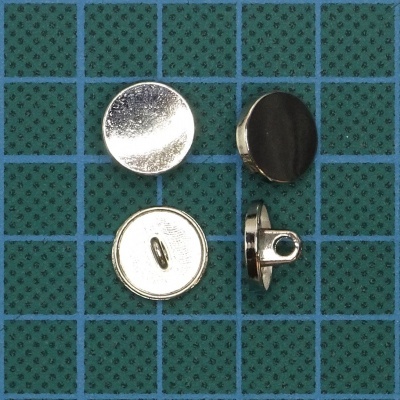 Botões metálicos prateados em superfície verde quadriculada