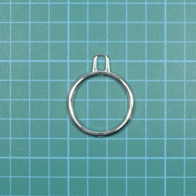 Anel de metal prateado sobre fundo de grade verde