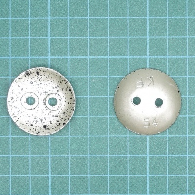 Dois botões redondos brancos sobre papel quadriculado azul