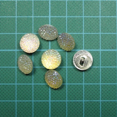 Botões redondos texturizados brilhantes em tons amarelo e verde sobre fundo quadriculado verde