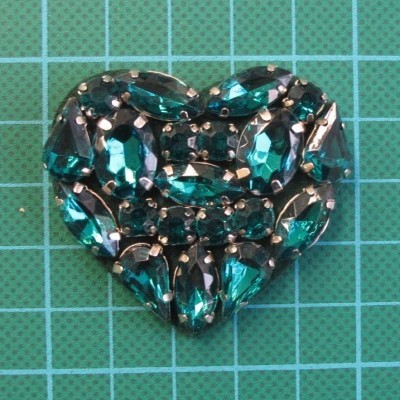 Aplicação Coração 4,3cm x 5cm com Pedras Cosidas cosidas sobre base de feltro com cola.