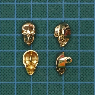 Contas douradas em forma de caveira sobre fundo verde com grade azul