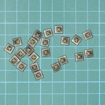 rebites metálicos quadrados bronze sobre superfície reticulada azul