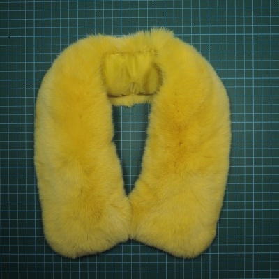 Gola de pele sintética amarela sobre superfície de grade verde escura