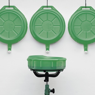 Três tabuleiros verdes redondos pendurados na parede, com um tabuleiro igual no suporte