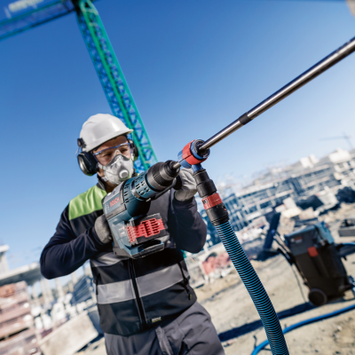 Trabalhador da construção a usar ferramenta elétrica num canteiro de obras