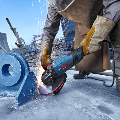 esmerilhadora elétrica Bosch Professional cortando metal com faíscas enquanto trabalhador utiliza equipamento de proteção