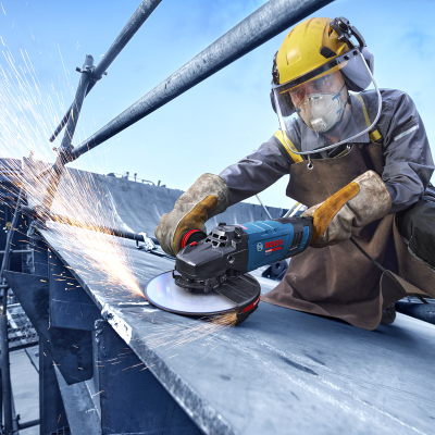 Pessoa a cortar chapa metálica com rebarbador elétrico BOSCH em ambiente industrial