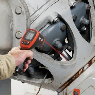 Termómetro infravermelho RECO a medir temperatura de máquina industrial cinza