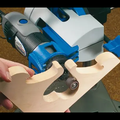 Ferramenta elétrica azul a desbastar madeira clara apoiada numa bancada