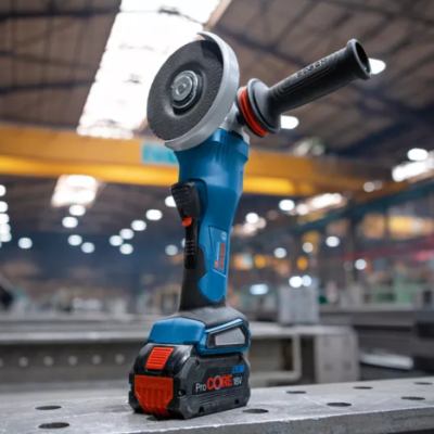 Esmerilhadora elétrica Bosch azul e preta com detalhes vermelhos numa bancada metálica em oficina industrial