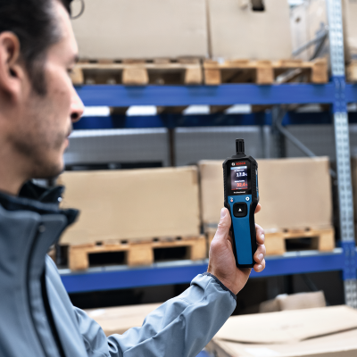 Dispositivo digital Bosch Professional em mãos de pessoa num armazém