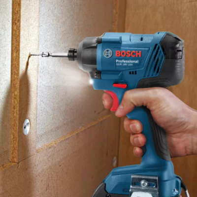 Furadeira/parafusadora azul Bosch Professional a aparafusar numa placa de madeira