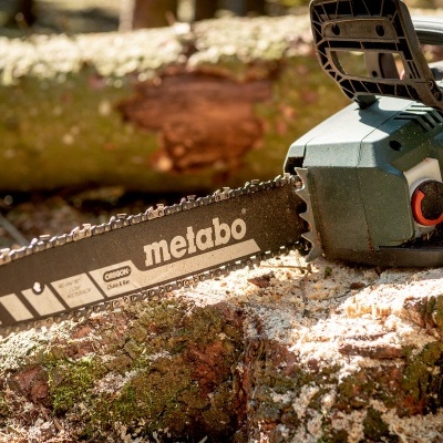 Motosserra Metabo a gasolina sobre tronco serrado
