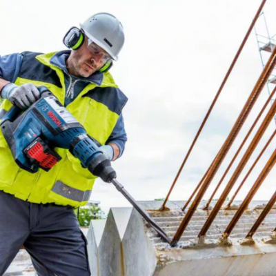 Homem a usar ferramenta elétrica Bosch em obra ao ar livre