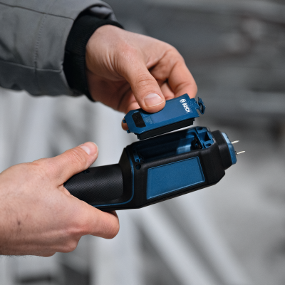 Dispositivo eletrônico portátil preto e azul com peça Bosch sendo encaixada