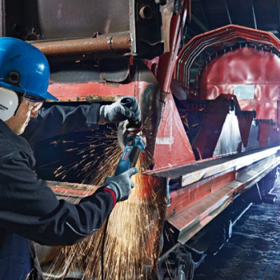Homem a usar esmerilhadeira em ambiente industrial