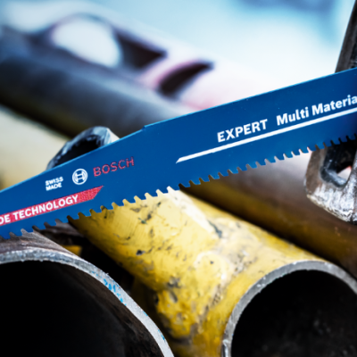 Lâmina de serra Bosch azul montada numa ferramenta sobre tubos metálicos coloridos