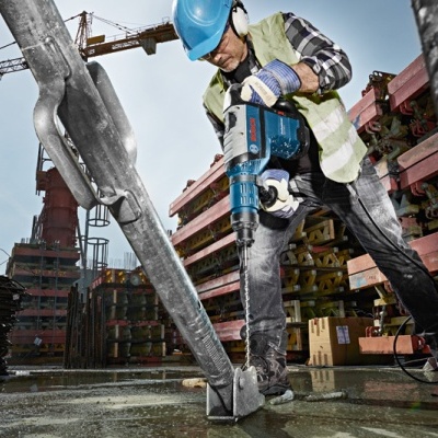 Trabalhador usando ferramenta elétrica em construção